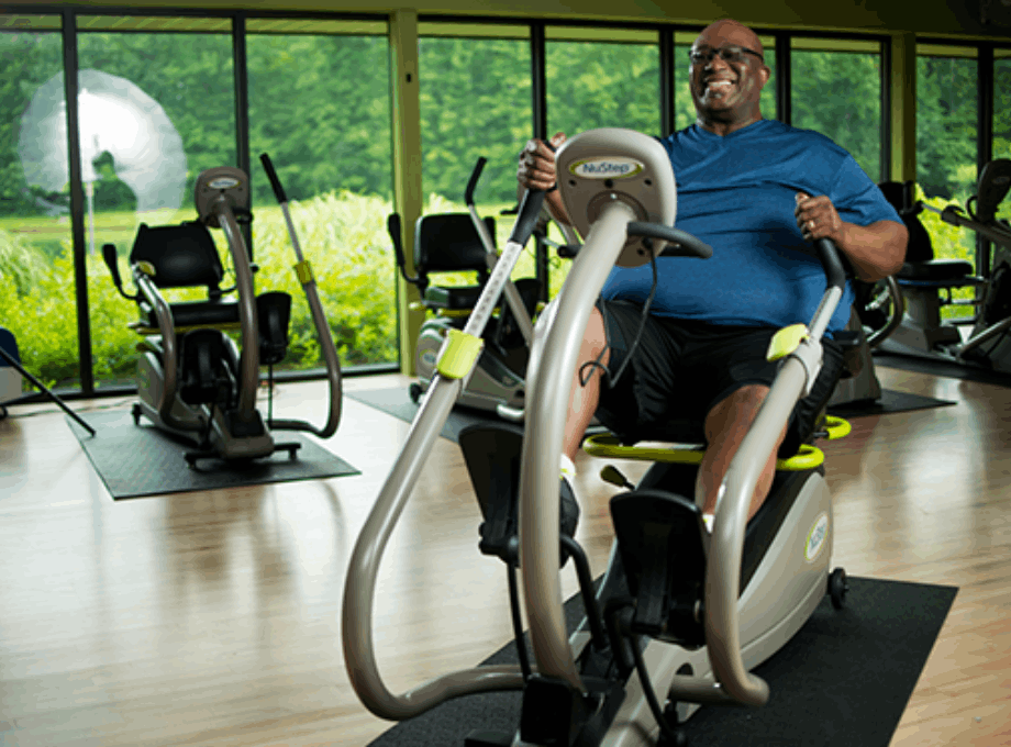 O'Neal-Hampton-smiling-while-exercising-on-a-nustep-seated-stepper