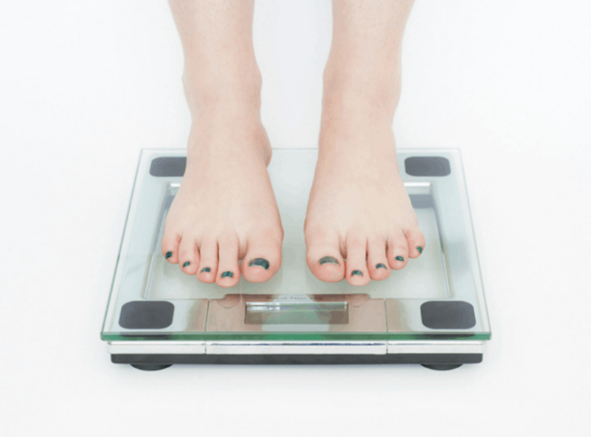 womans_feet_standing_on_scale_weighing_herself