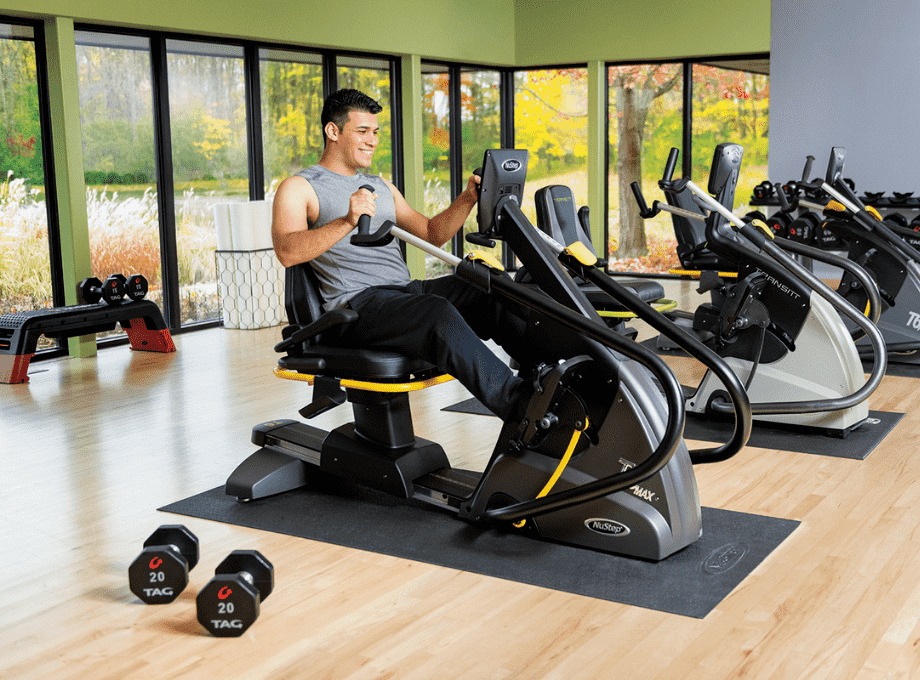 Younger_man_exercising_on_recumbent_cross_trainer_nustep_in_gym