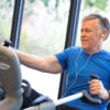 Older Man On Recumbent Cross Trainer Stepper Exercising at Gym