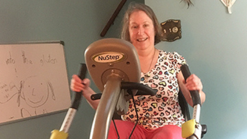 older_woman_smiling_while_working_out_on_seated_stepper